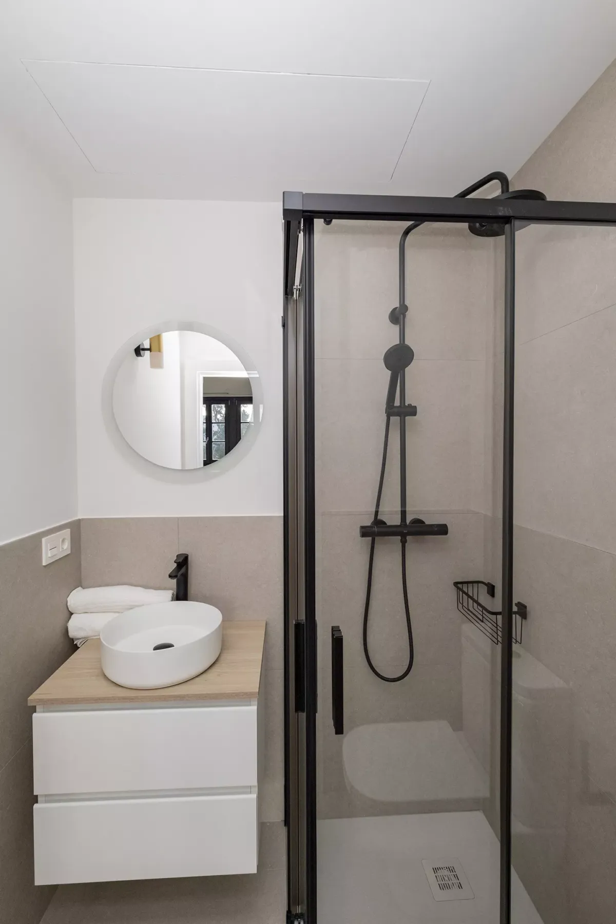 Ducha cerrada, lavabo y espejo