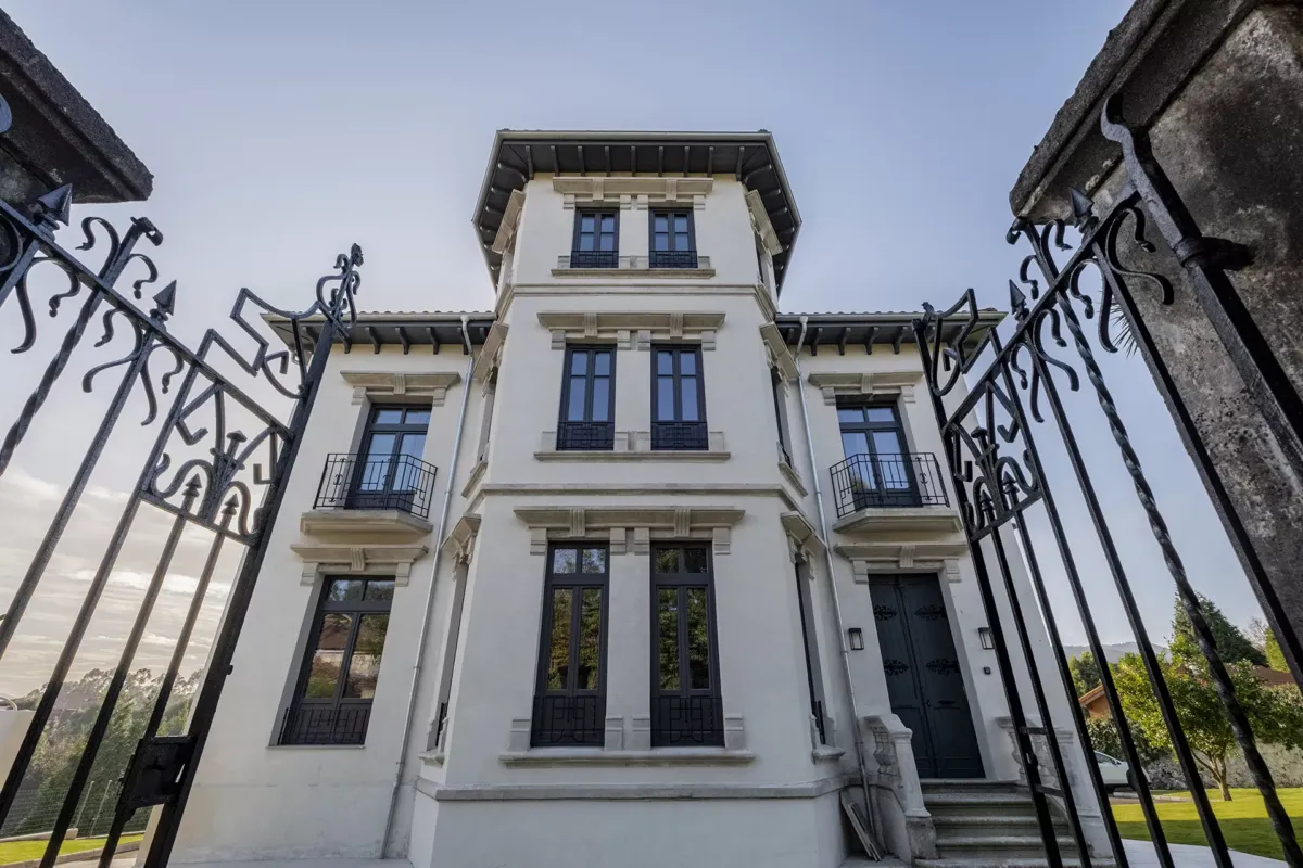 Entrada con rejas y casa de fondo