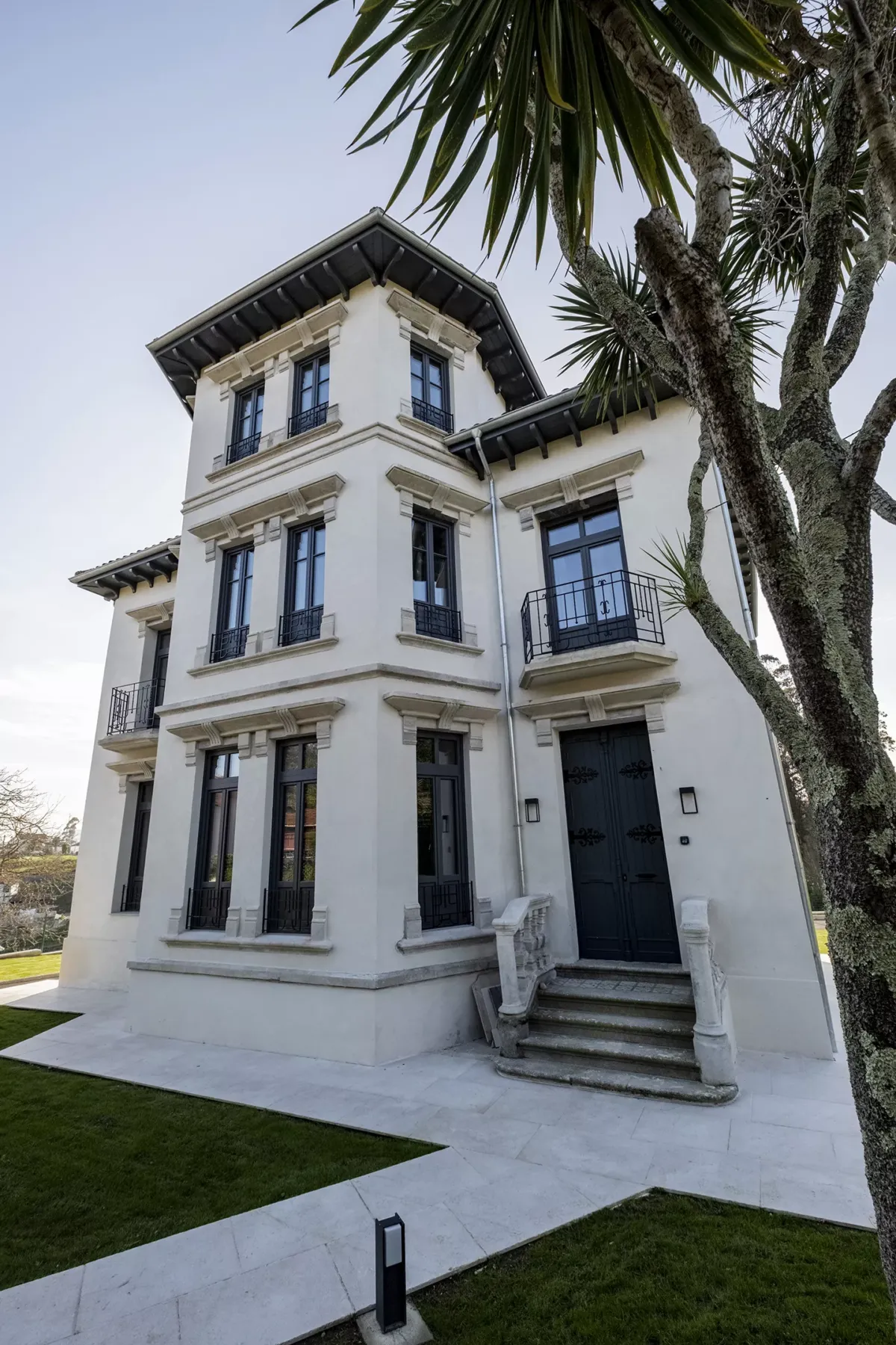 Casa de dos plantas con árbol a un costado