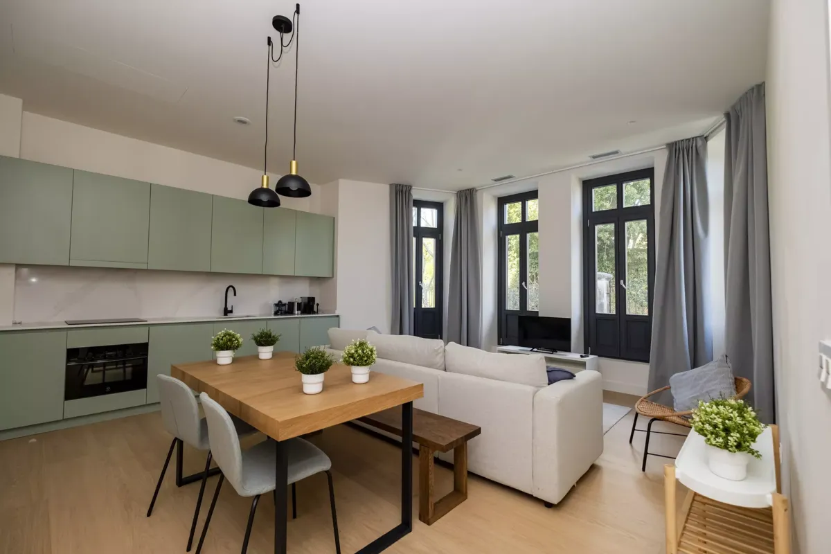 Salón con mesa y sillas, sofá y ventanas con vistas