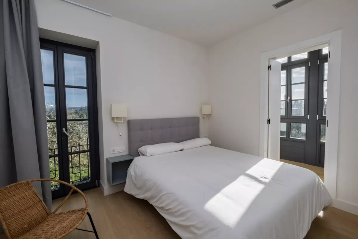 Cama matrimonial, silla y ventana