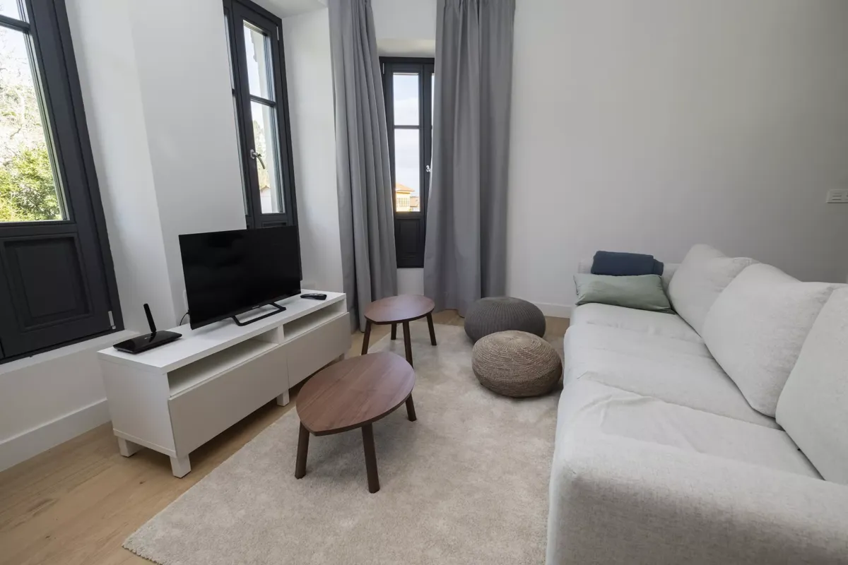 Sala de estar con sofás, mesillas y TV