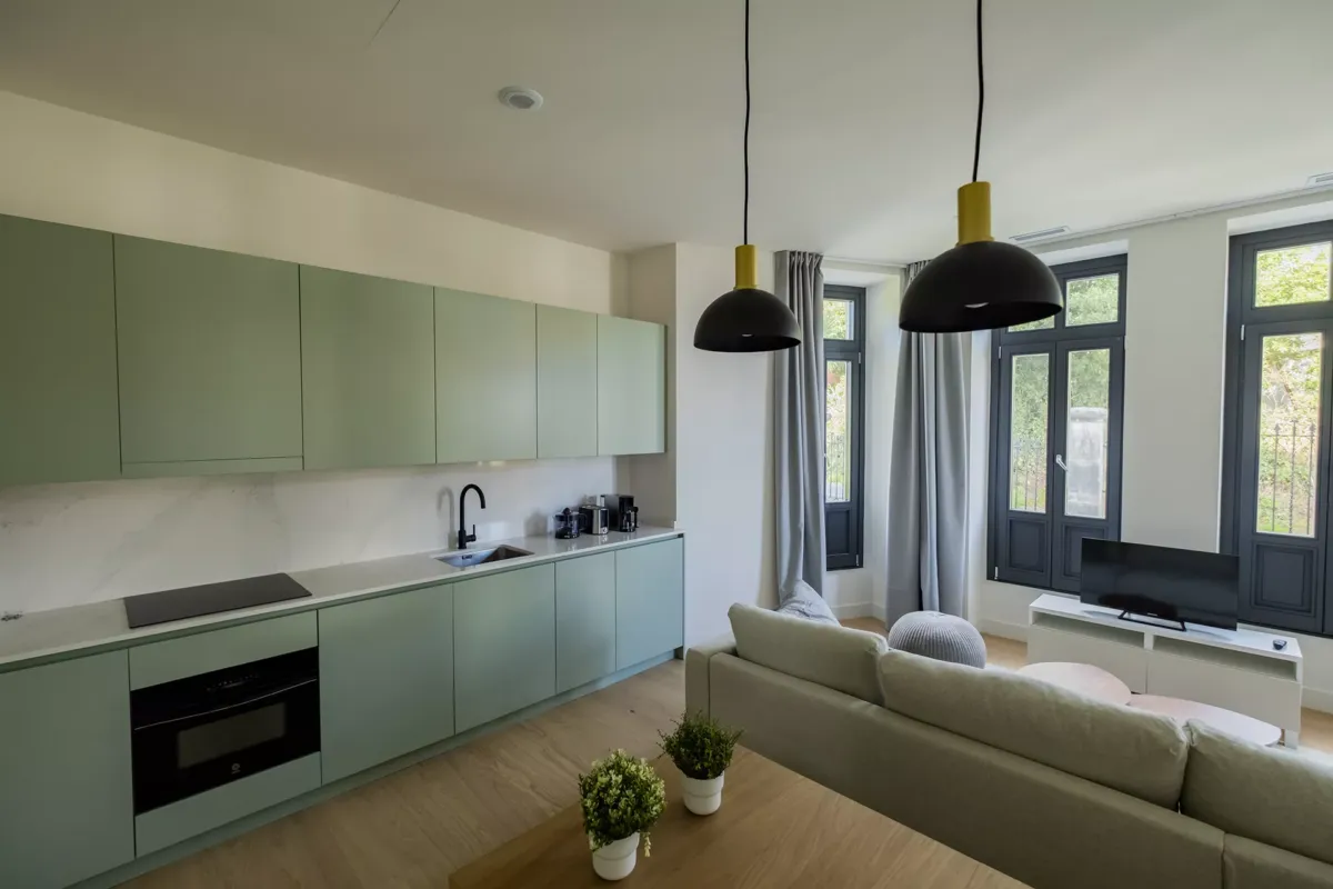 Cocina, mesa con macetas de decoración, sofá y lámparas.